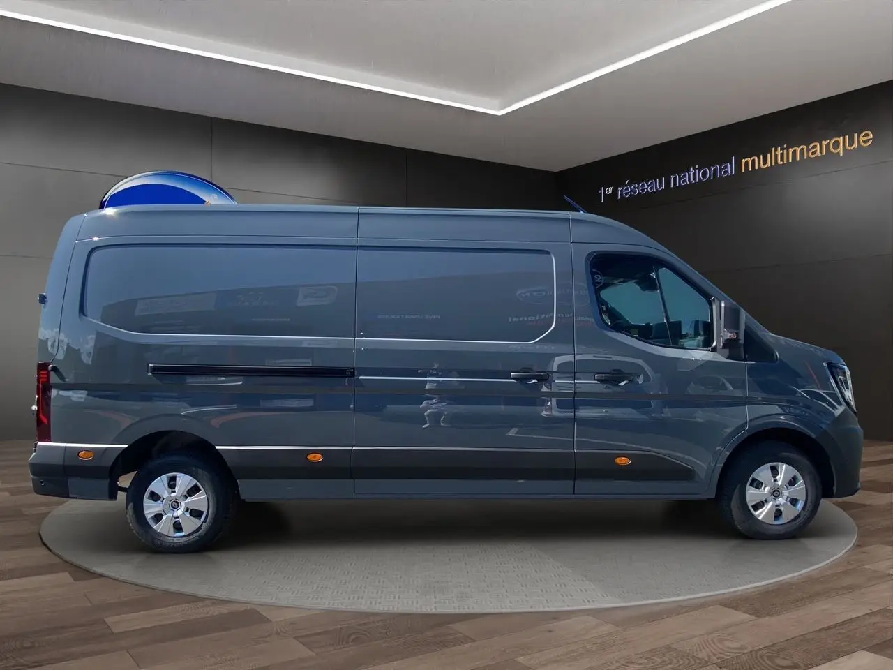 Renault Master 2025 gris urbain en profil droit, fourgon utilitaire avec portes arrière tôlées ouvertes à 270° visibles en arrière-plan.
