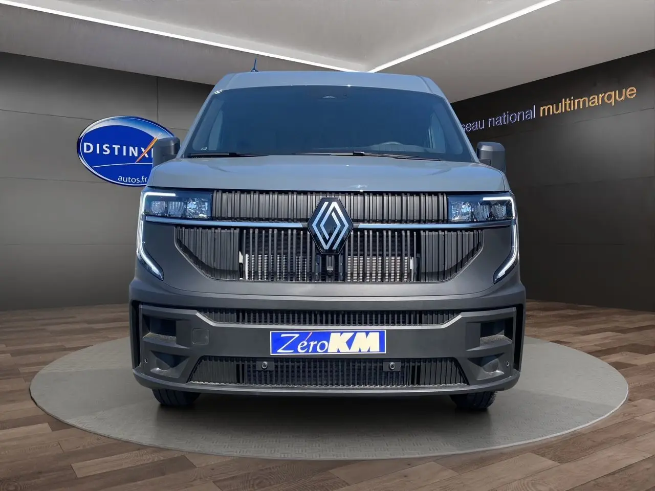 Vue de face du Renault Master 2025 gris urbain avec calandre noire et phares LED intégrés, en showroom.