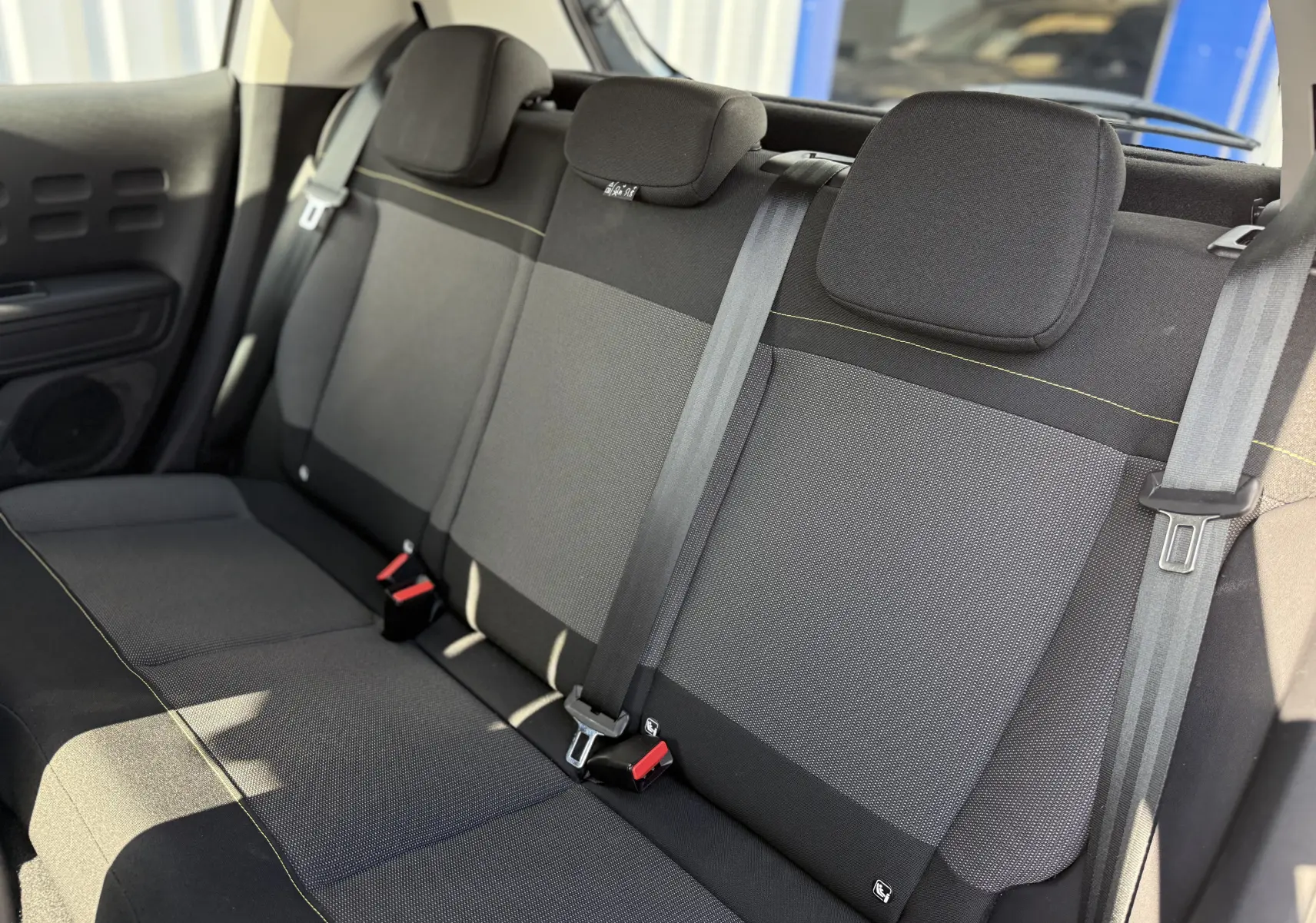 Vue intérieure montrant la banquette arrière noire et grise avec ceintures et appuie-têtes du Citroën C3 2023.