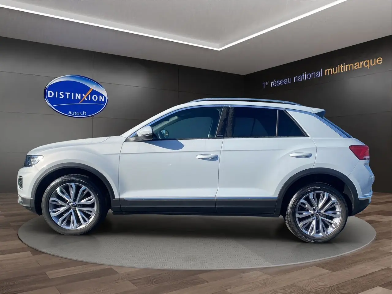 Profil latéral droit du Volkswagen T-Roc 2021 en blanc argenté avec jantes alu 18 pouces et toit ouvrant panoramique.