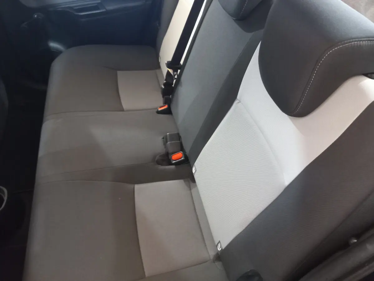 Banquette arrière bicolore gris clair et foncé de la Toyota Yaris 1.5 Hybrid vue côté droit, avec ceintures et appuie-têtes.