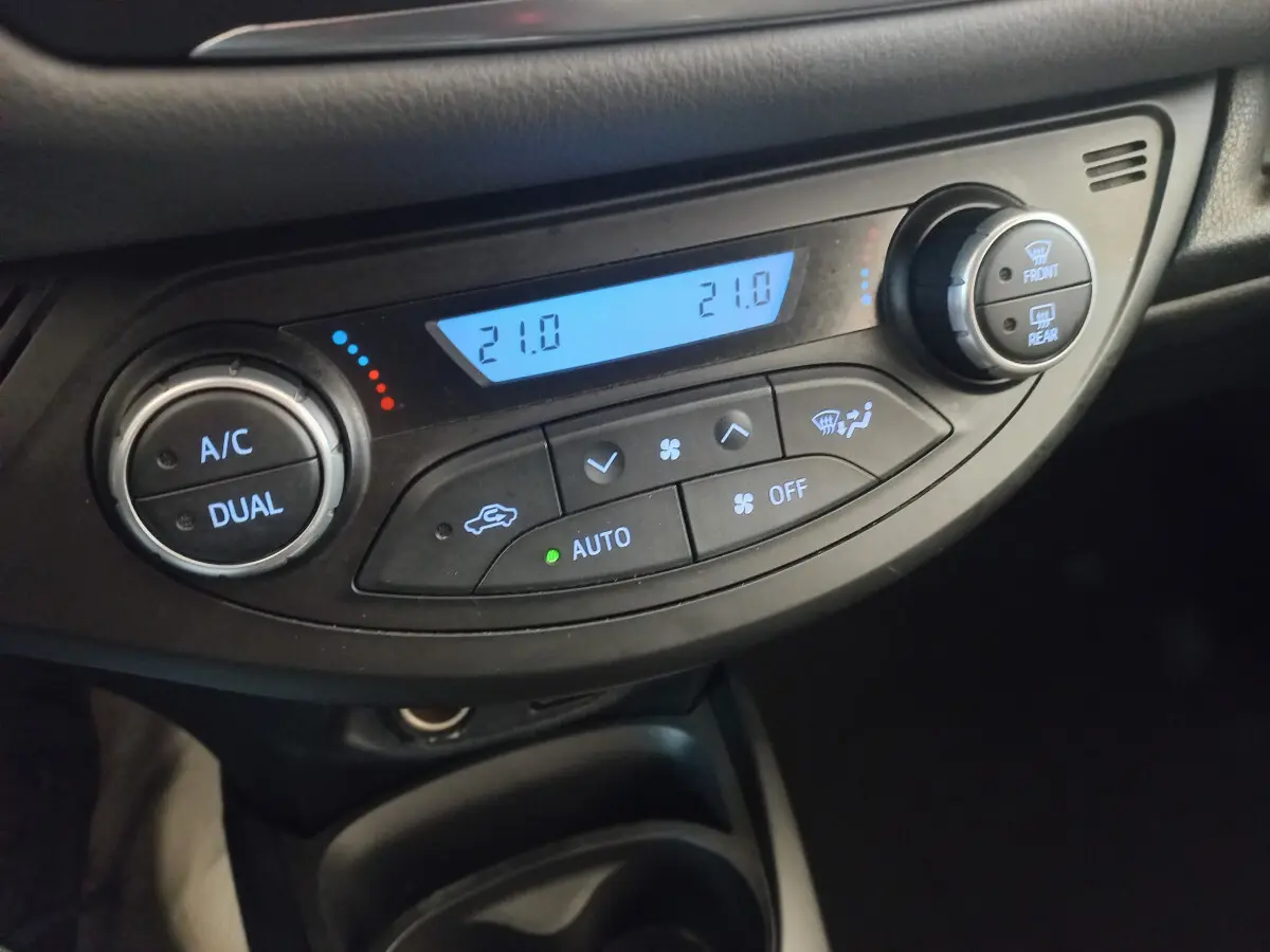 Gros plan sur la commande de climatisation 2 zones avec écran digital bleu de la Toyota Yaris noire 2018 France Business.