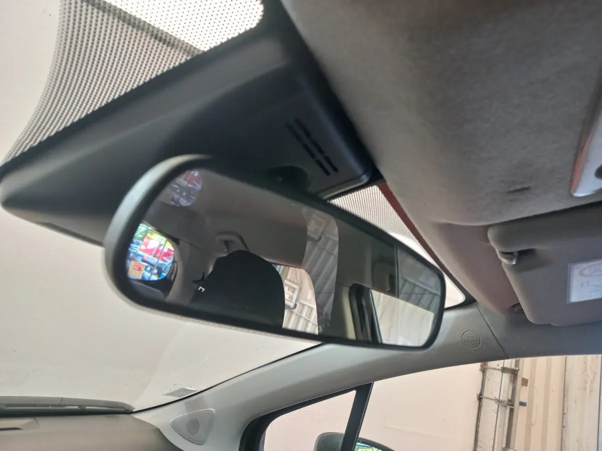 Vue intérieure du rétroviseur central de la Toyota Yaris noire, montrant l'arrière du siège conducteur et une partie du toit.