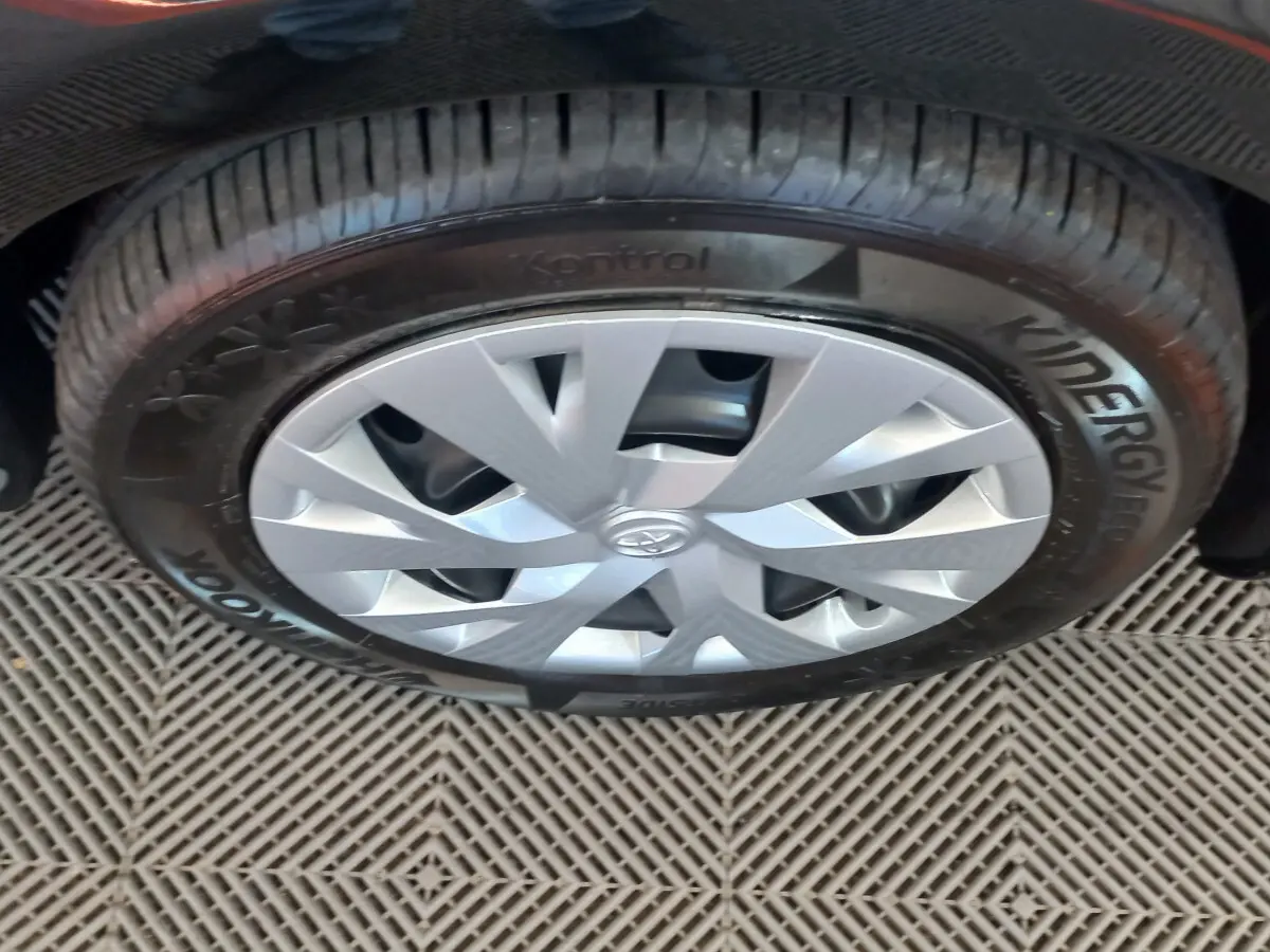 Gros plan sur la roue avant droite de la Toyota Yaris noire, avec jante argentée et pneu Hankook Kinergy Eco.