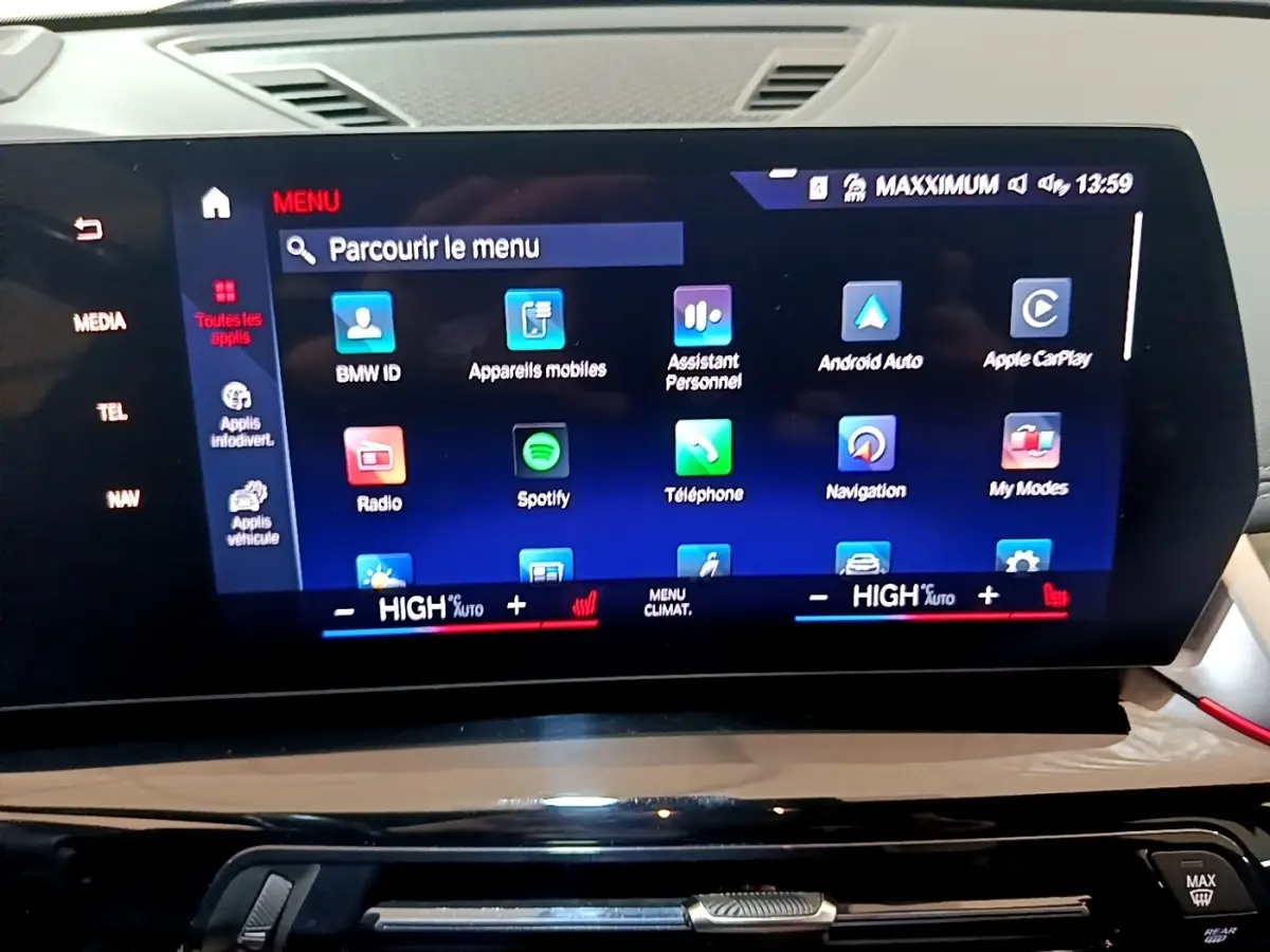 Écran tactile central du tableau de bord du BMW X1 gris clair, affichant le menu multimédia et navigation.