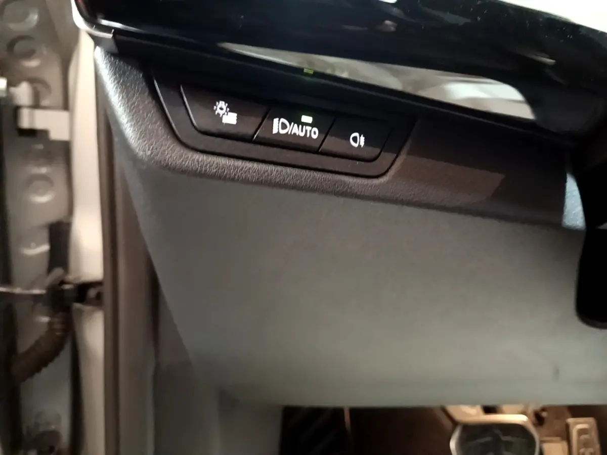 Détail du tableau de bord côté gauche avec commandes d’éclairage sur BMW X1 xDrive23i M Sport gris clair 2023.