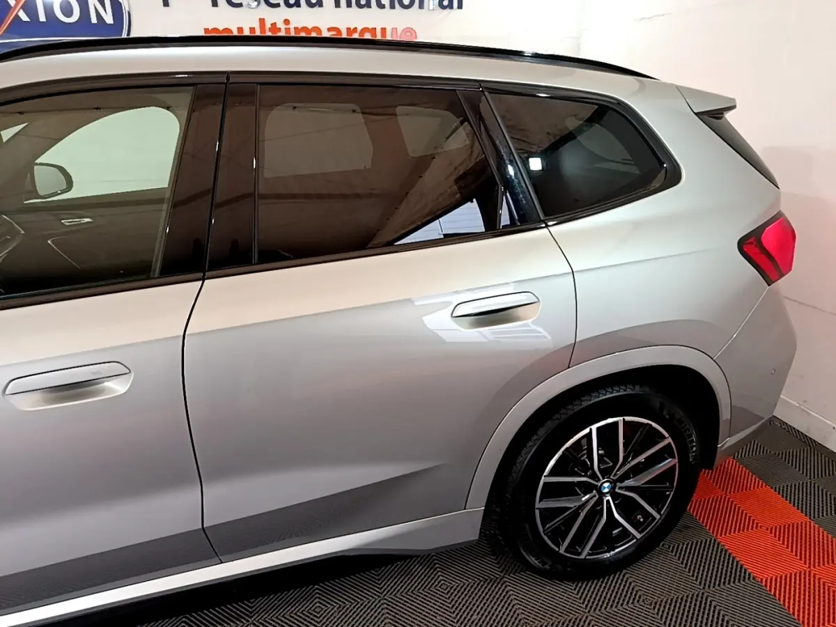Vue latérale droite du BMW X1 xDrive23i M Sport gris clair, mettant en valeur les jantes alliage et les vitres teintées.