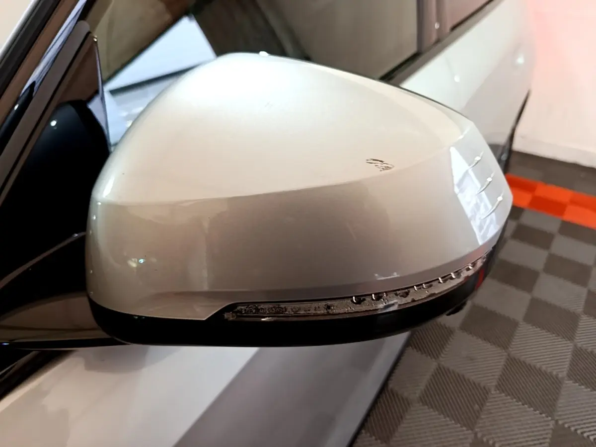 Gros plan sur le rétroviseur droit gris clair du BMW X1 xDrive23i M Sport avec clignotant intégré.