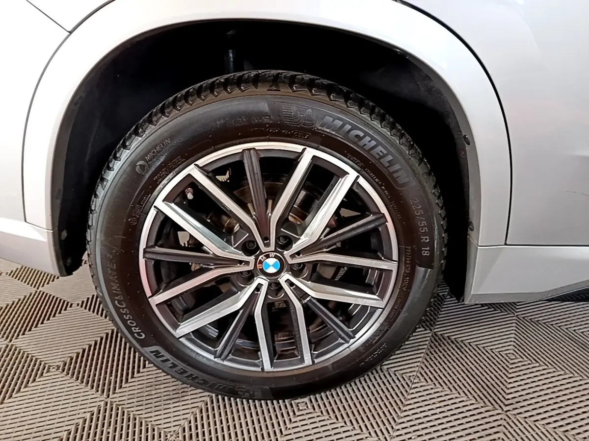 Gros plan sur la roue avant droite gris clair d’un BMW X1 xDrive23i M Sport 2023 avec jante alliage et pneu Michelin.