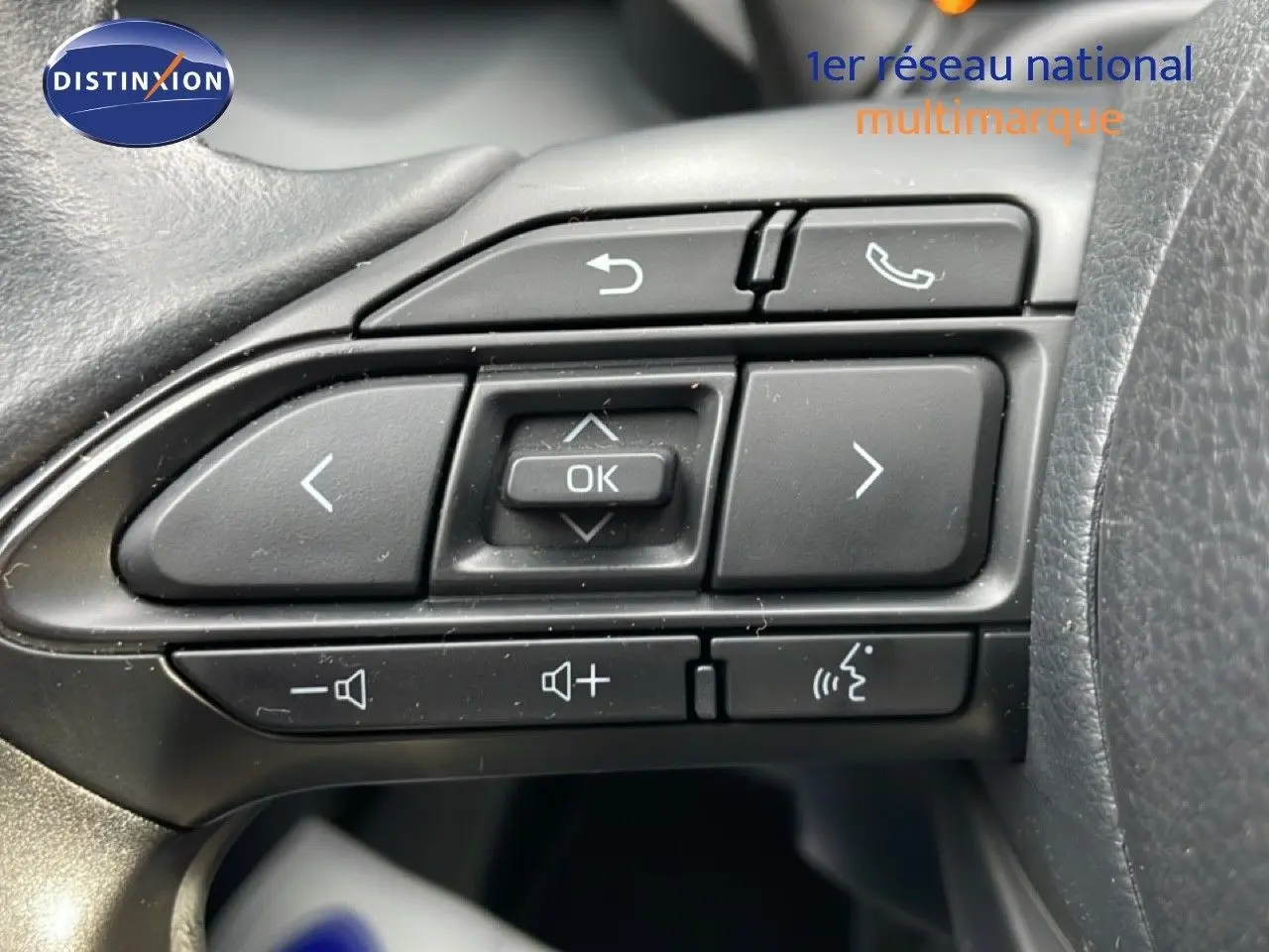 Gros plan sur les commandes multifonctions noires au volant du Toyota Yaris Cross blanc pur 2024.