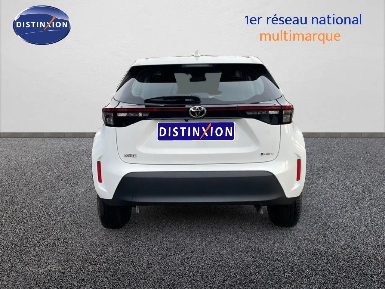 Vue arrière de la Toyota Yaris Cross 2024 blanche, soulignant son bandeau lumineux noir et son pare-chocs contrasté.