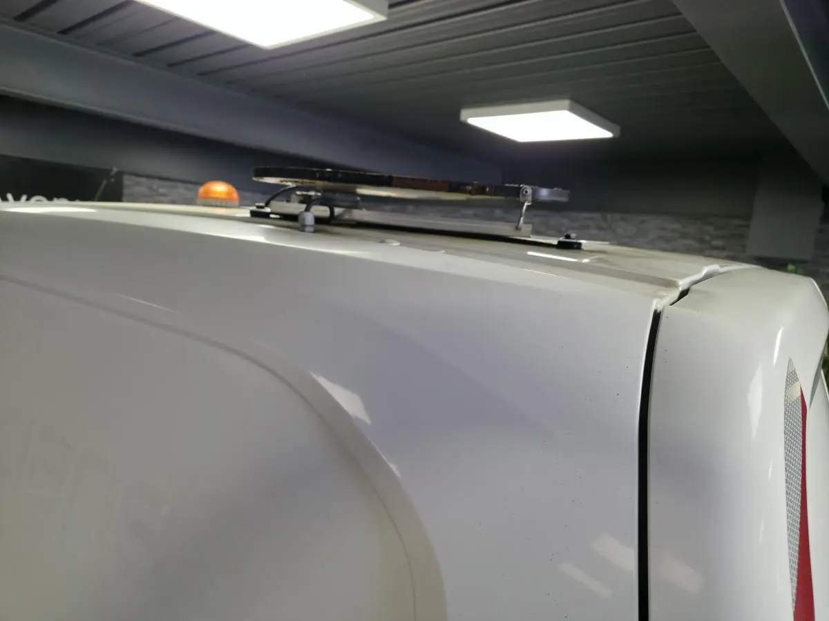 Vue rapprochée du toit blanc du Peugeot Partner 2021 avec son gyrophare orange et l'antenne de toit visible.