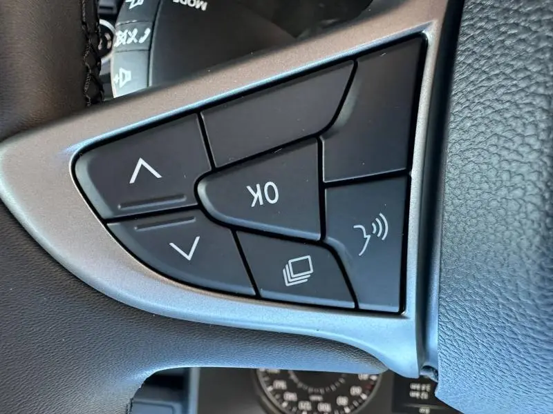 Gros plan sur les commandes multifonctions noires du volant côté gauche du Dacia Jogger blanc 2024.