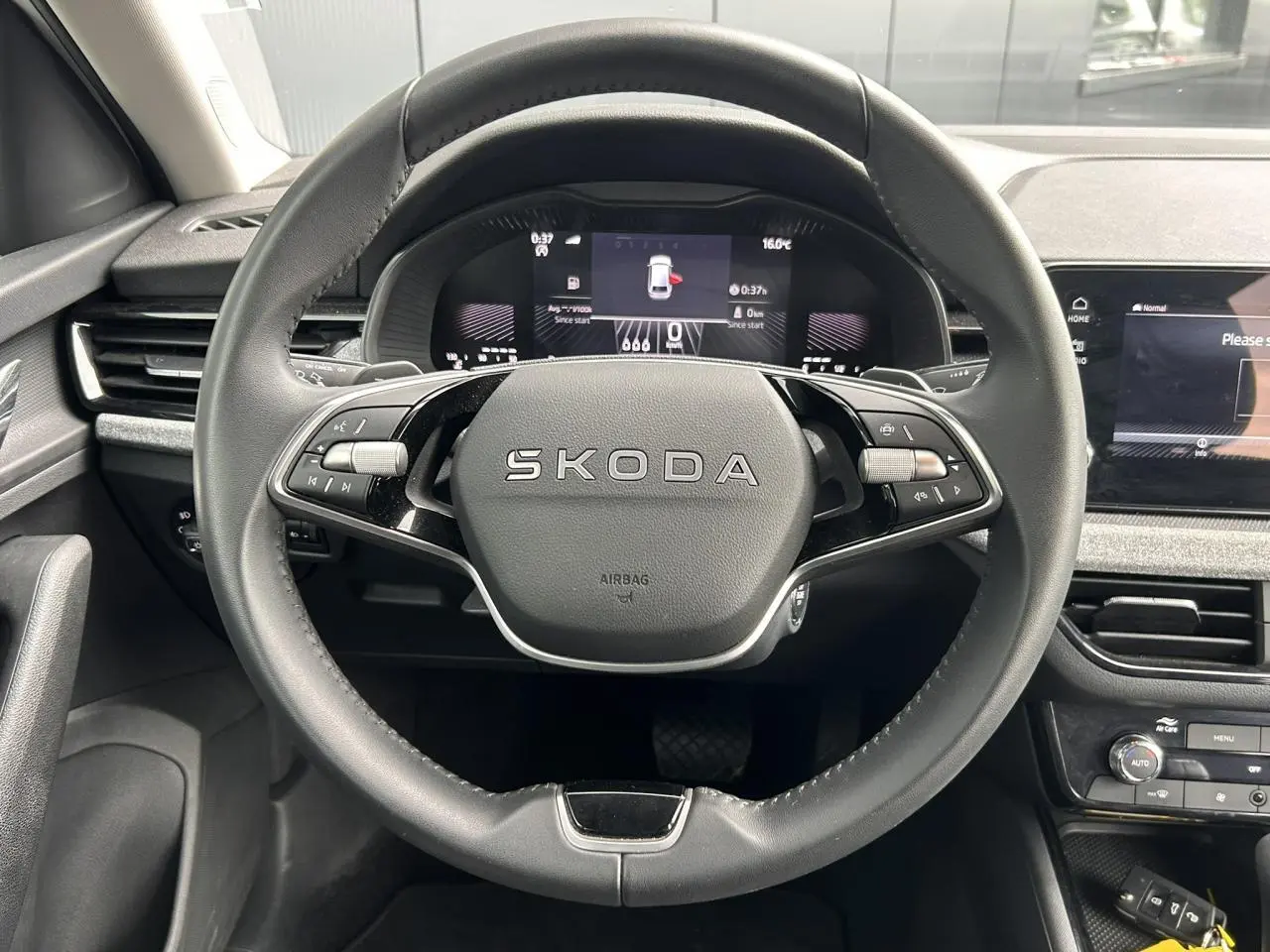 Vue frontale du volant en cuir noir multifonctions de la Skoda Scala 2025 avec tableau de bord digital et écran tactile.
