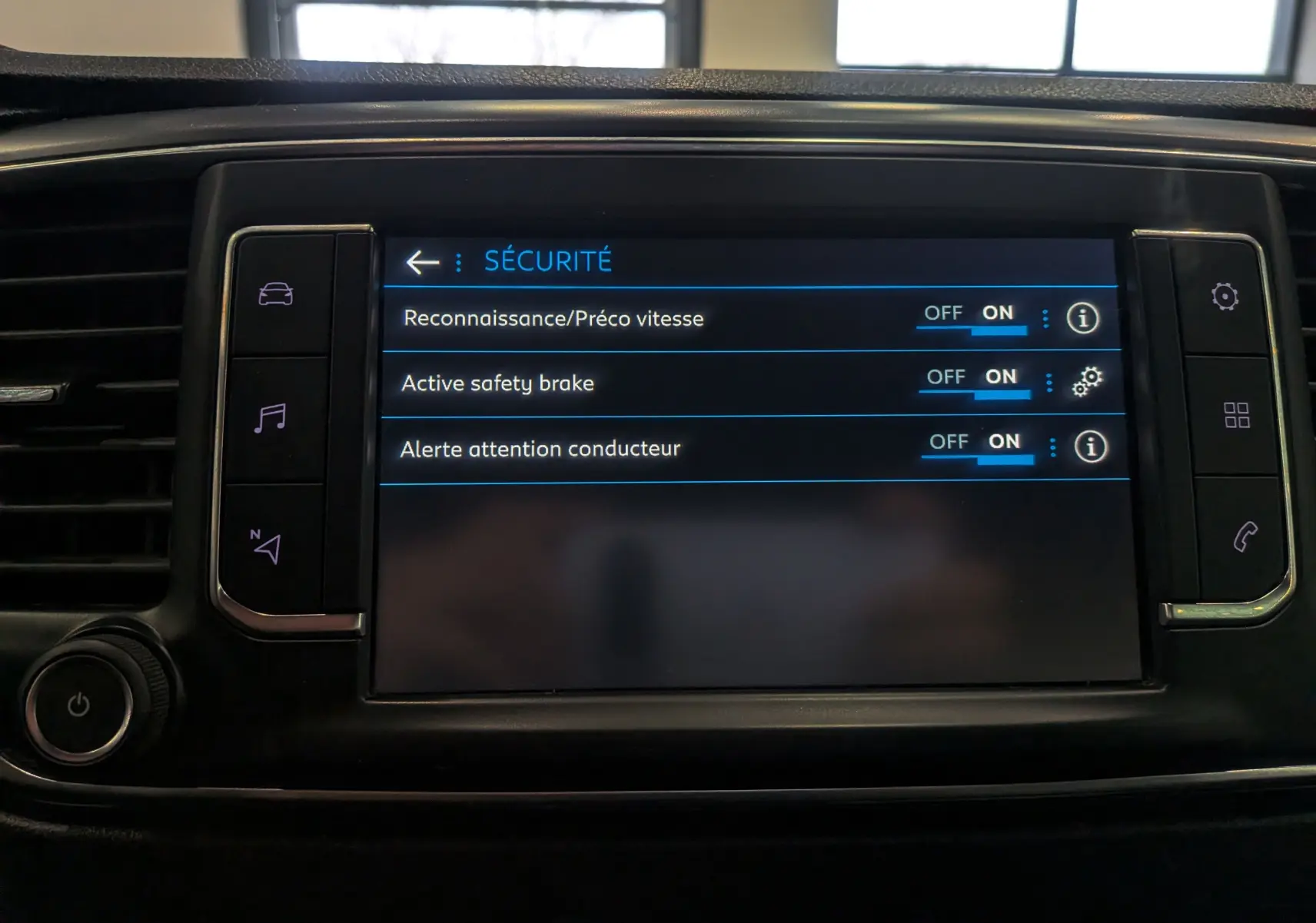 Écran tactile du tableau de bord du Peugeot Expert Fourgon noir, affichant les réglages de sécurité activés.