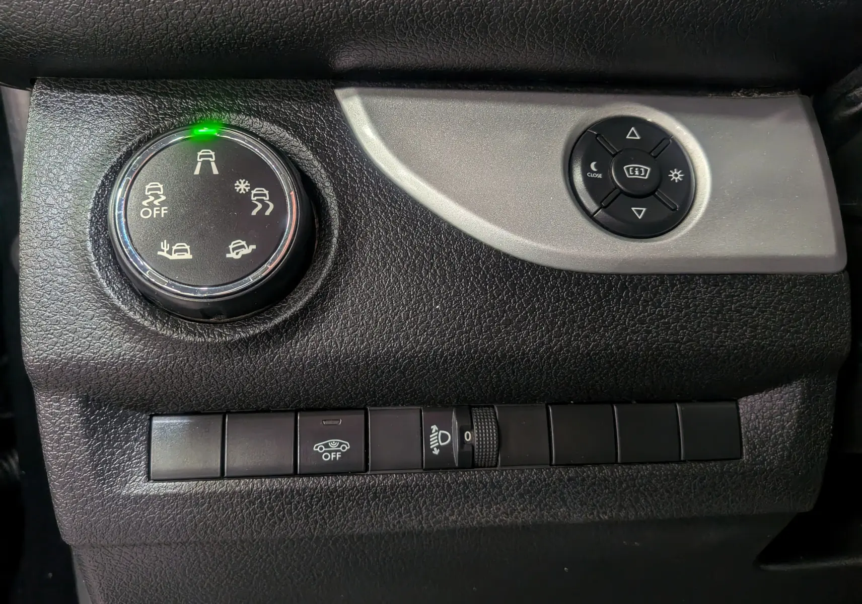 Gros plan sur les commandes noires du tableau de bord du Peugeot Expert Fourgon, avec bouton de réglage des aides à la conduite.