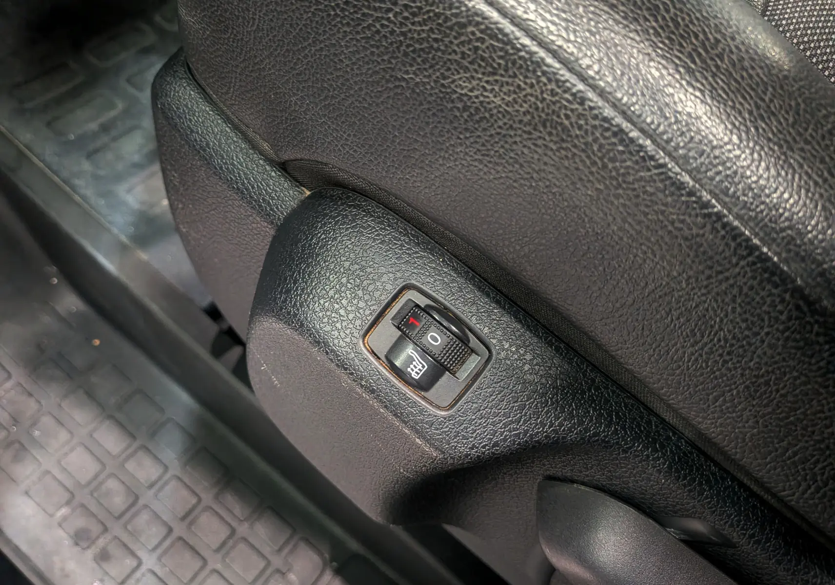 Détail du bouton de réglage du siège chauffant en cuir noir dans le Peugeot Expert Fourgon Standard BlueHDi 180.