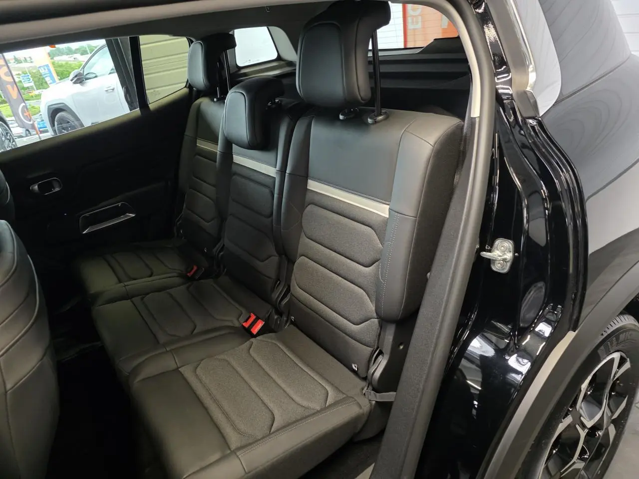 Vue intérieure côté droit des trois sièges arrière indépendants noirs du Citroën C5 Aircross 2025 hybride.