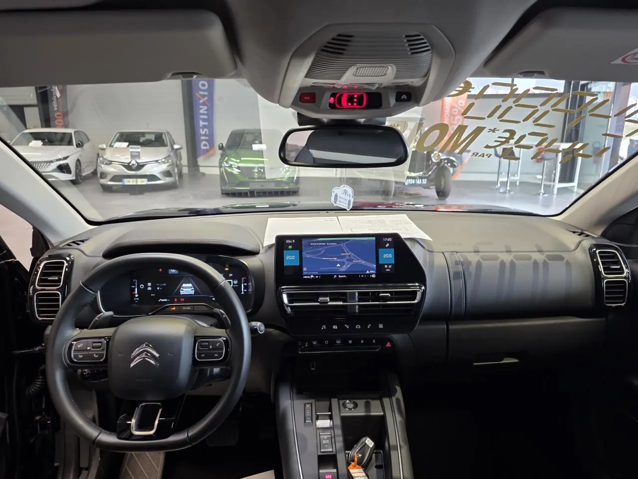 Vue intérieure avant du Citroën C5 Aircross noir métal, tableau de bord avec écran tactile et volant multifonctions.
