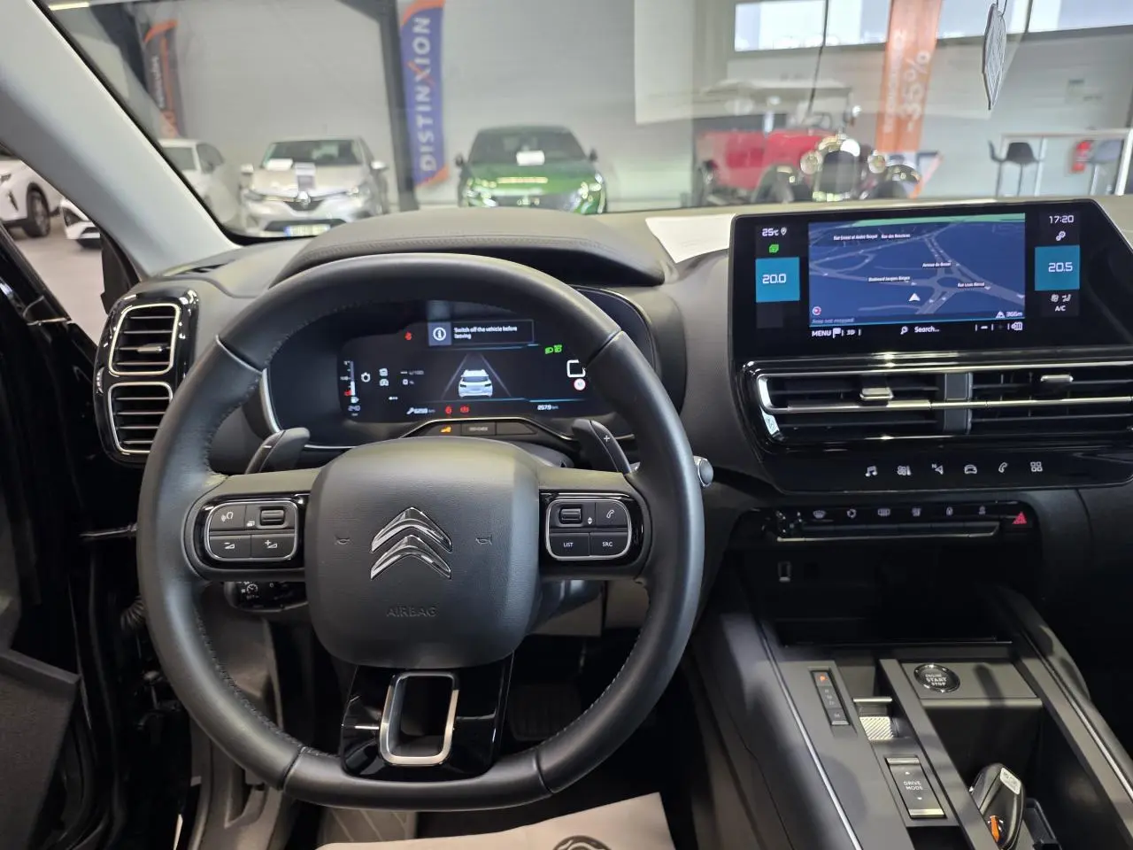 Vue intérieure centrée sur le volant noir et l'écran tactile du tableau de bord du Citroën C5 Aircross 2025.