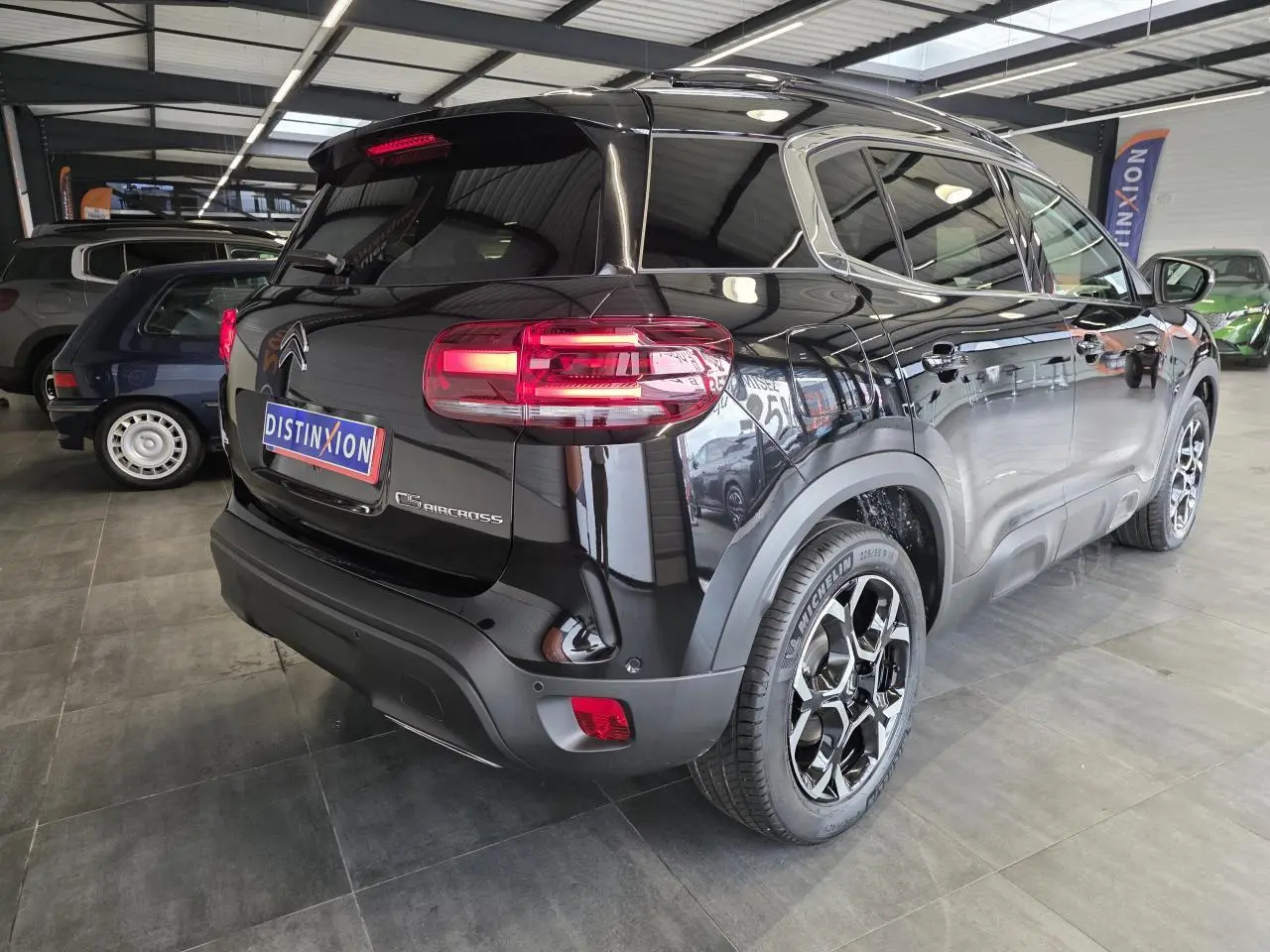 Vue 3/4 arrière droite du Citroën C5 Aircross noir métal avec jantes alliage bi-ton et feux arrière LED 3D allumés.