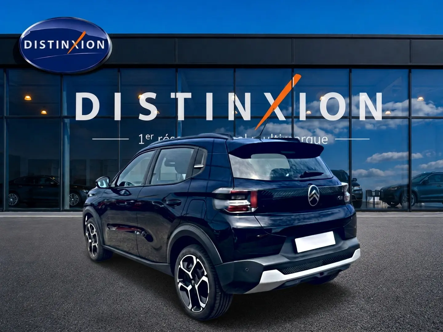 Vue 3/4 arrière droite d'une Citroën C3 113 Plus électrique noire, avec jantes distinctives et détails arrière modernes.