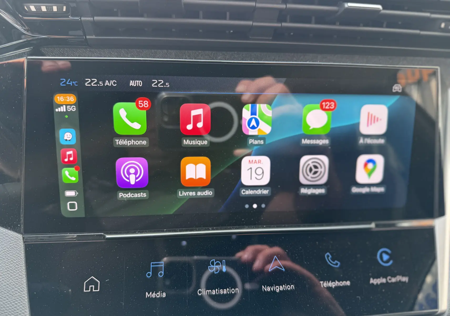 Écran tactile central de la Peugeot 308 2025 gris Artense affichant Apple CarPlay avec applications et notifications.