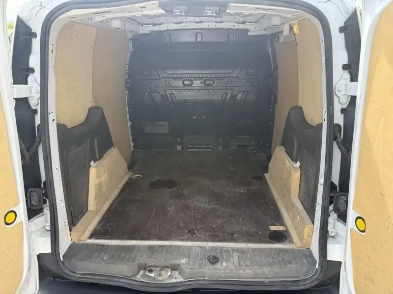 Vue intérieure arrière du Ford Transit Connect blanc glacier 2019, montrant l'espace de chargement vide avec parois boisées.