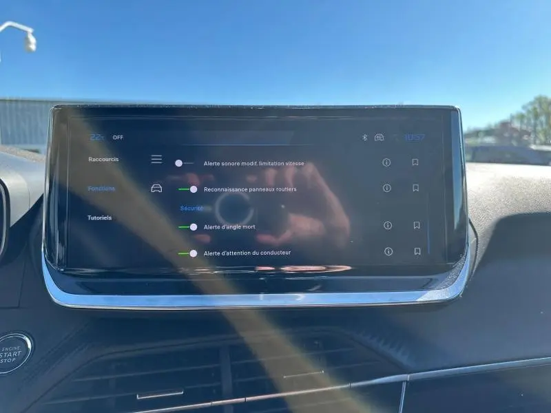 Écran tactile central du tableau de bord du Peugeot 2008 1.2 Hybrid 145ch Allure en lumière naturelle.