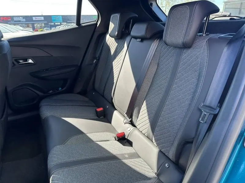 Vue intérieure côté droit des sièges arrière du Peugeot 2008 2025 en Bleu Obsession, avec sellerie tissu et ceintures visibles.