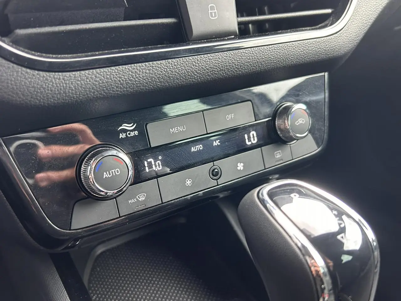 Gros plan sur la console centrale noire du Skoda Scala 2025, montrant la climatisation automatique bi-zone et le levier de vitesse.
