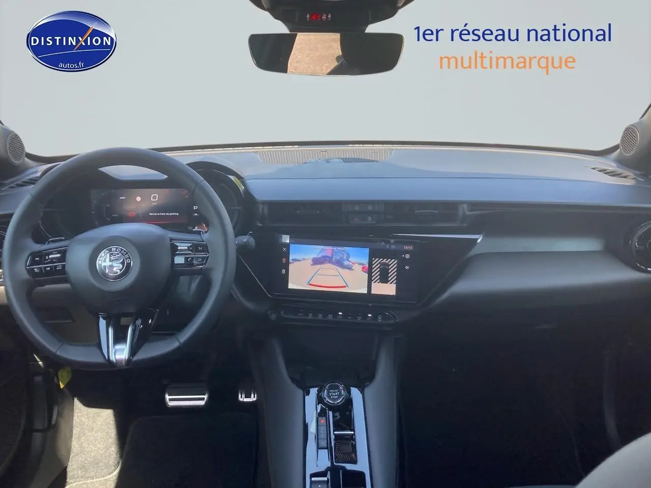 Vue intérieure avant de l'Alfa Romeo Junior 1.2 hybride ivoire/noir, avec écran tactile et volant multifonction.