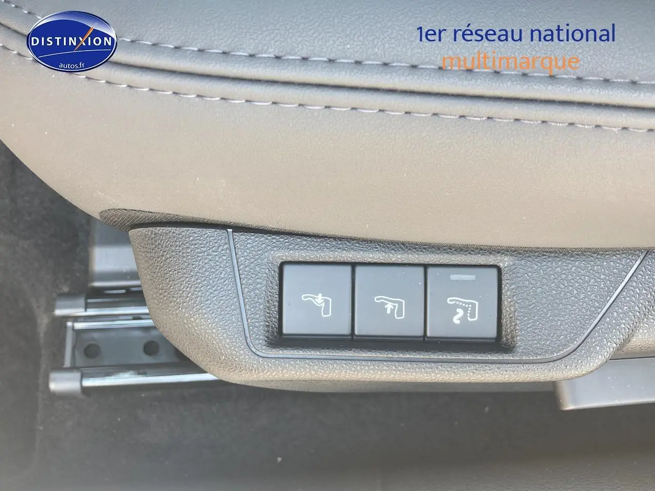 Gros plan sur les commandes de réglage électrique du siège conducteur en cuir gris clair de l'Alfa Romeo Junior 1.2 hybride ivoire et noir.