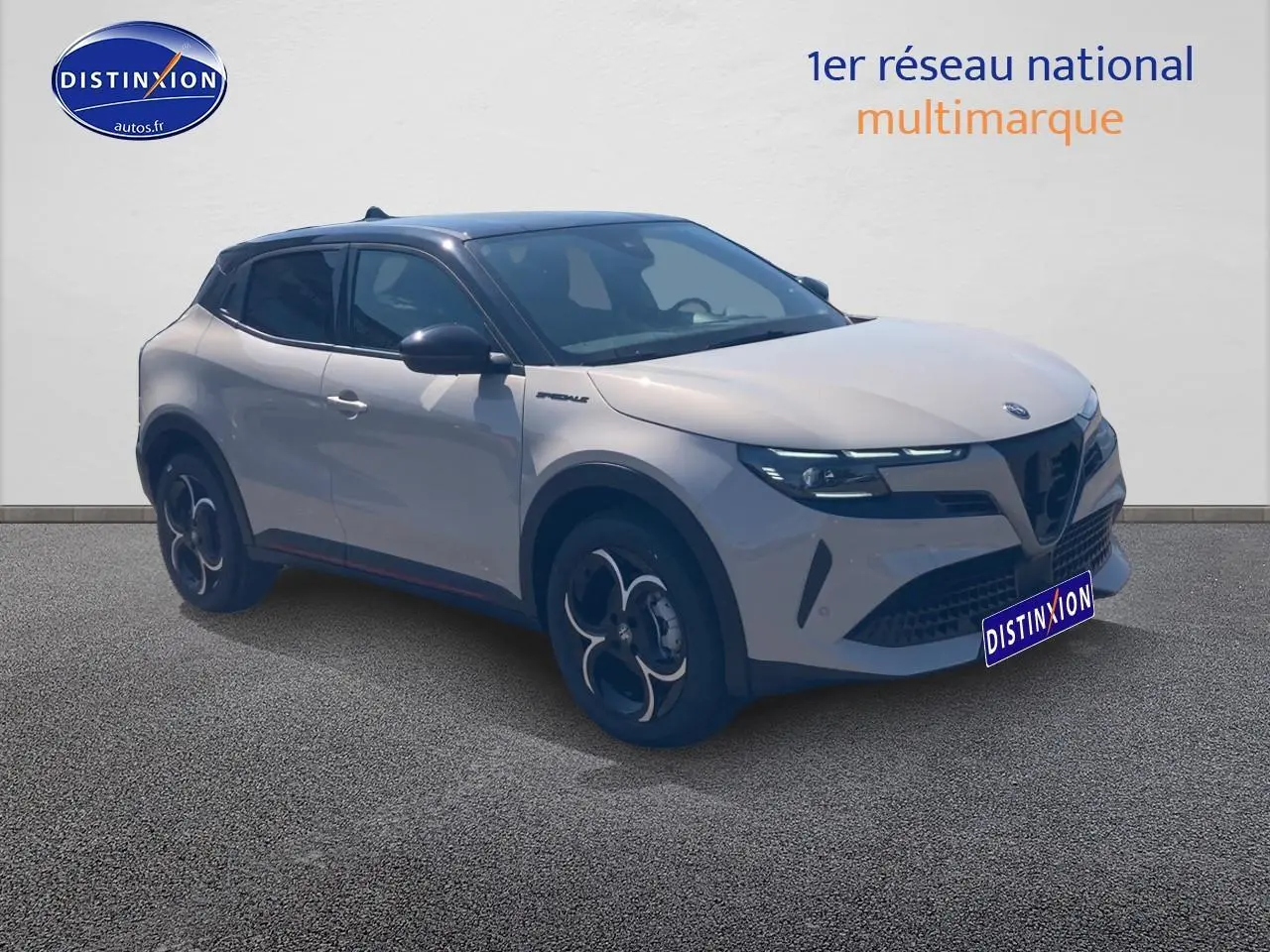 Alfa Romeo Junior 1.2 hybride 2026 en 3/4 avant, couleur ivoire et toit noir avec jantes en alliage distinctives.