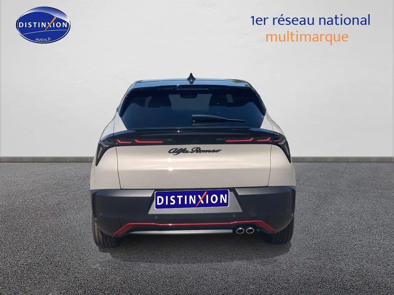 Vue arrière d'une Alfa Romeo Junior 1.2 hybride ivoire et noir avec feux LED et double sortie d'échappement visible.