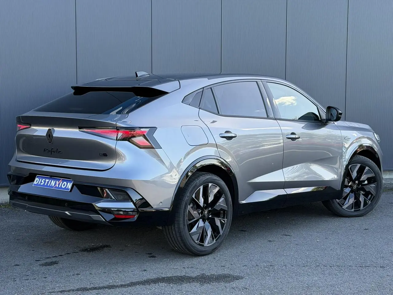 Renault Rafale E-Tech gris schiste en 3/4 arrière droit, avec jantes noires et hayon électrique visible.