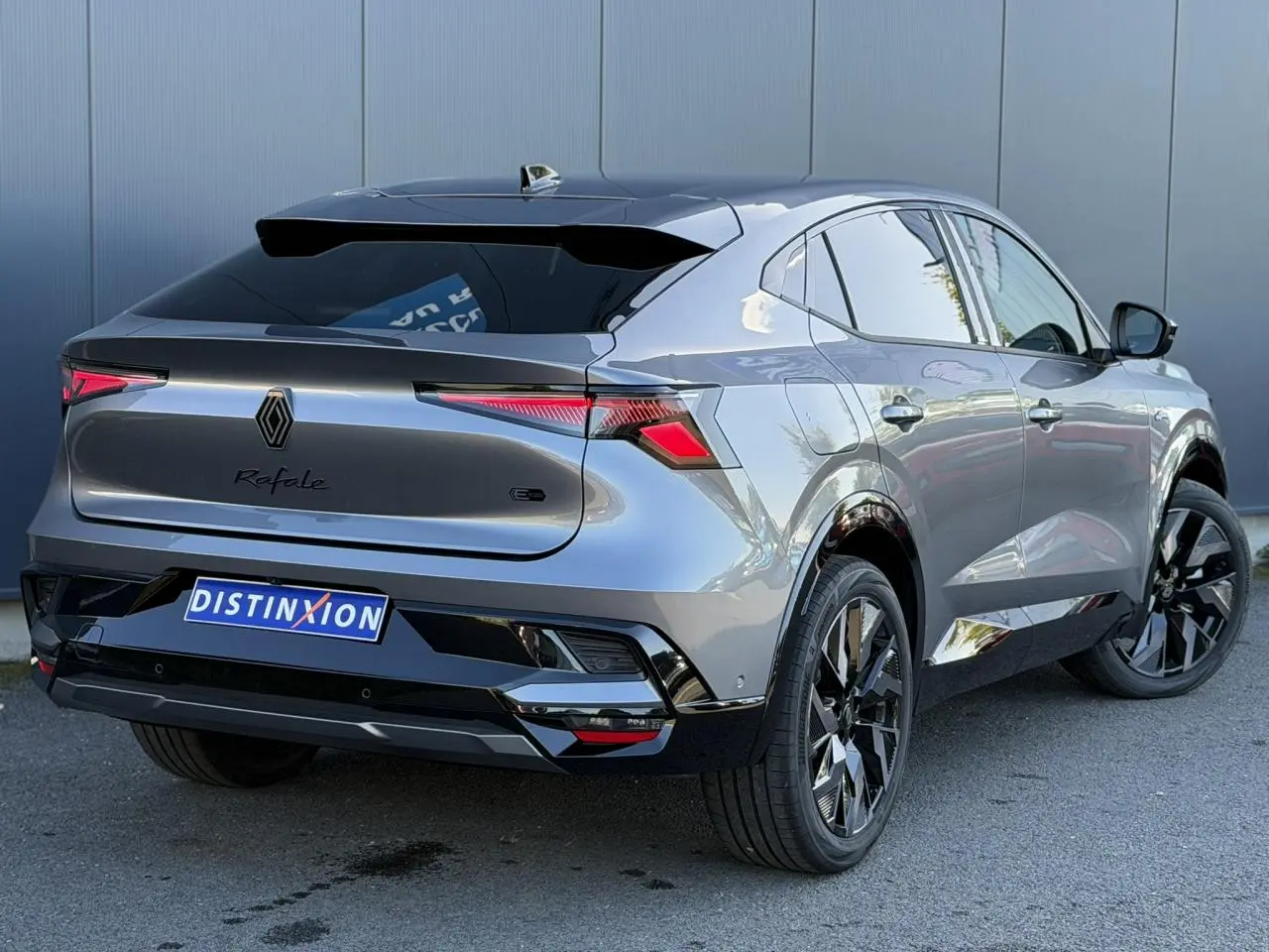 Renault Rafale E-Tech gris schiste en 3/4 arrière droit, jantes noires diamantées et hayon électrique visible.