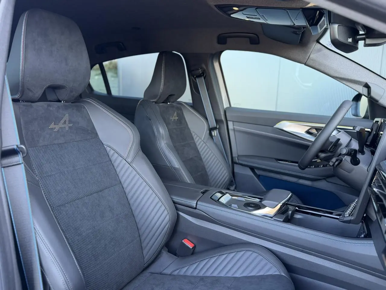 Vue intérieure côté conducteur de la Renault Rafale E-Tech gris avec sièges sport Alcantara et surpiqûres tricolores.