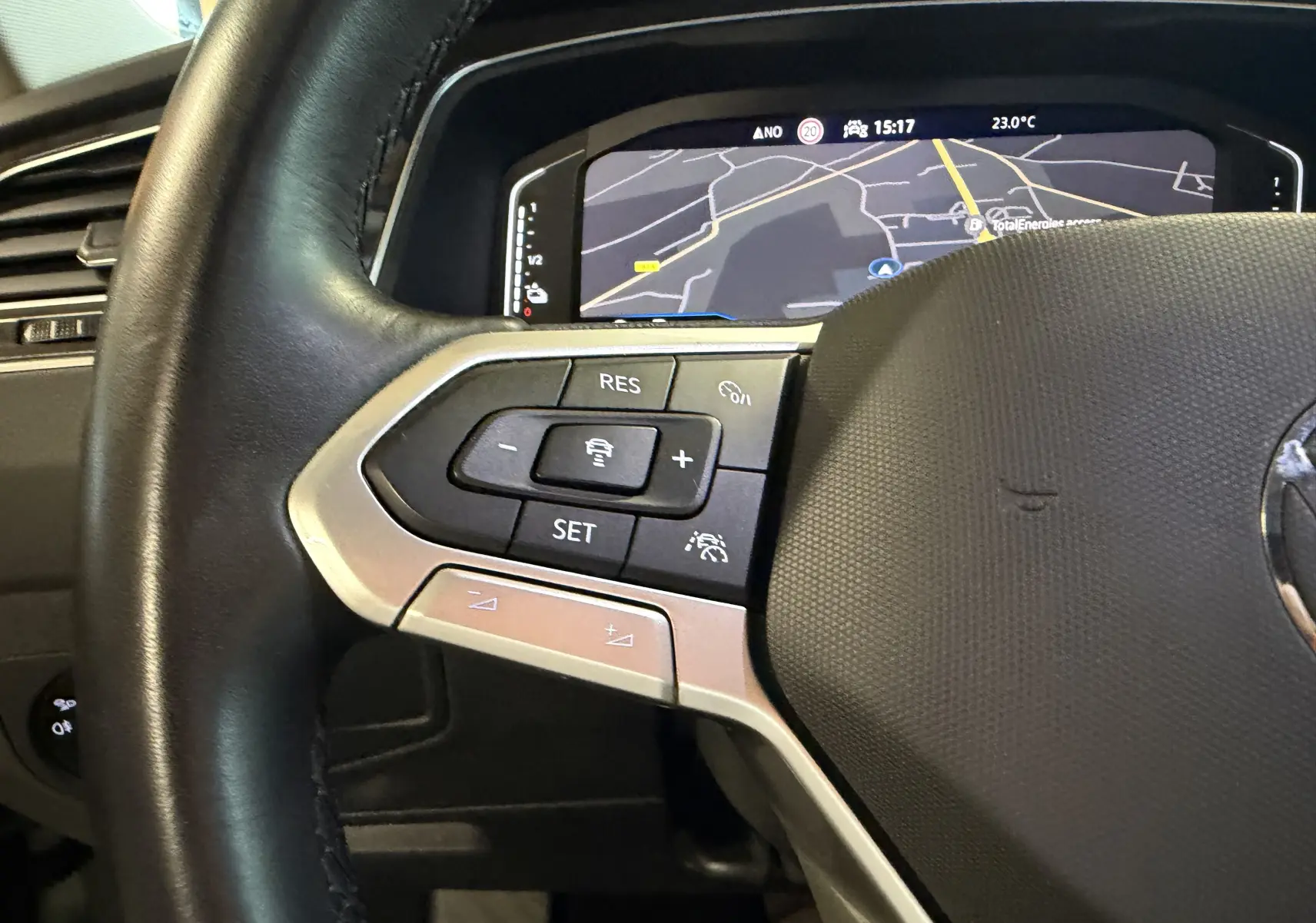Gros plan sur le volant et les commandes à gauche du Volkswagen Tiguan 1.4 E-HYBRID 2022 avec affichage numérique du tableau de bord.
