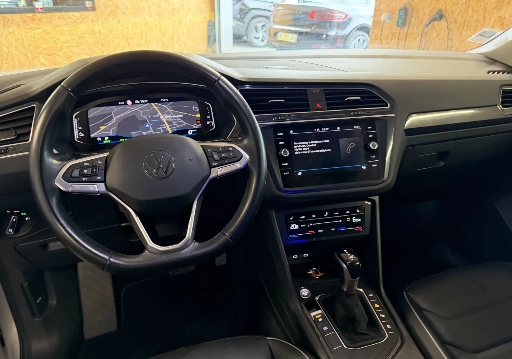 Vue intérieure du Volkswagen Tiguan 1.4 E-HYBRID 2022, tableau de bord noir avec écran tactile et volant multifonction.