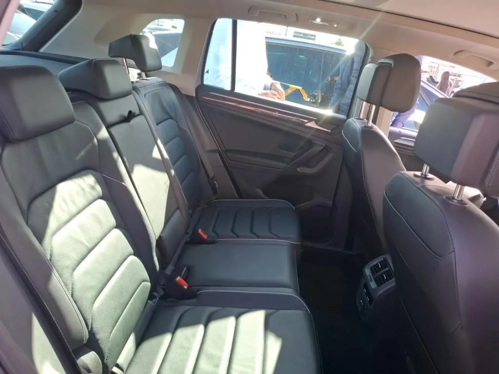 Vue intérieure côté droit des sièges arrière en cuir noir du Volkswagen Tiguan 1.4 E-HYBRID 2022, avec porte et fenêtre visibles.