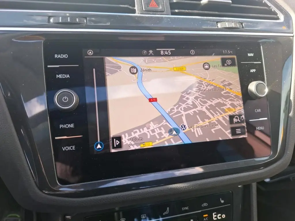 Vue rapprochée de l’écran tactile du système de navigation du Volkswagen Tiguan gris clair 2022, affichant une carte routière.