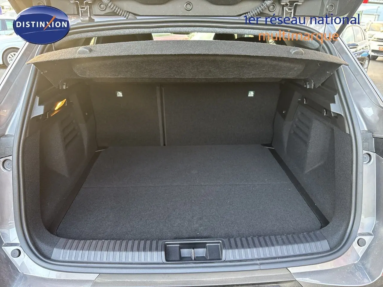 Coffre ouvert vu de l'arrière d'une Renault Symbioz gris Cassiopée Métal, espace de chargement spacieux et propre.