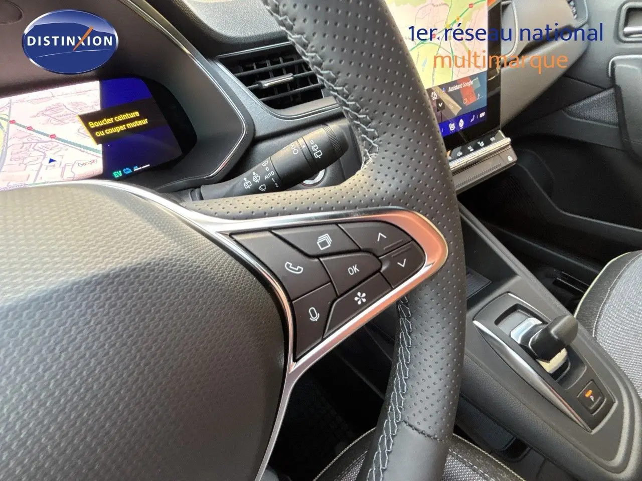 Gros plan sur le volant et la console centrale de la Renault Symbioz gris cassiopée, avec écran tactile et commandes intégrées.