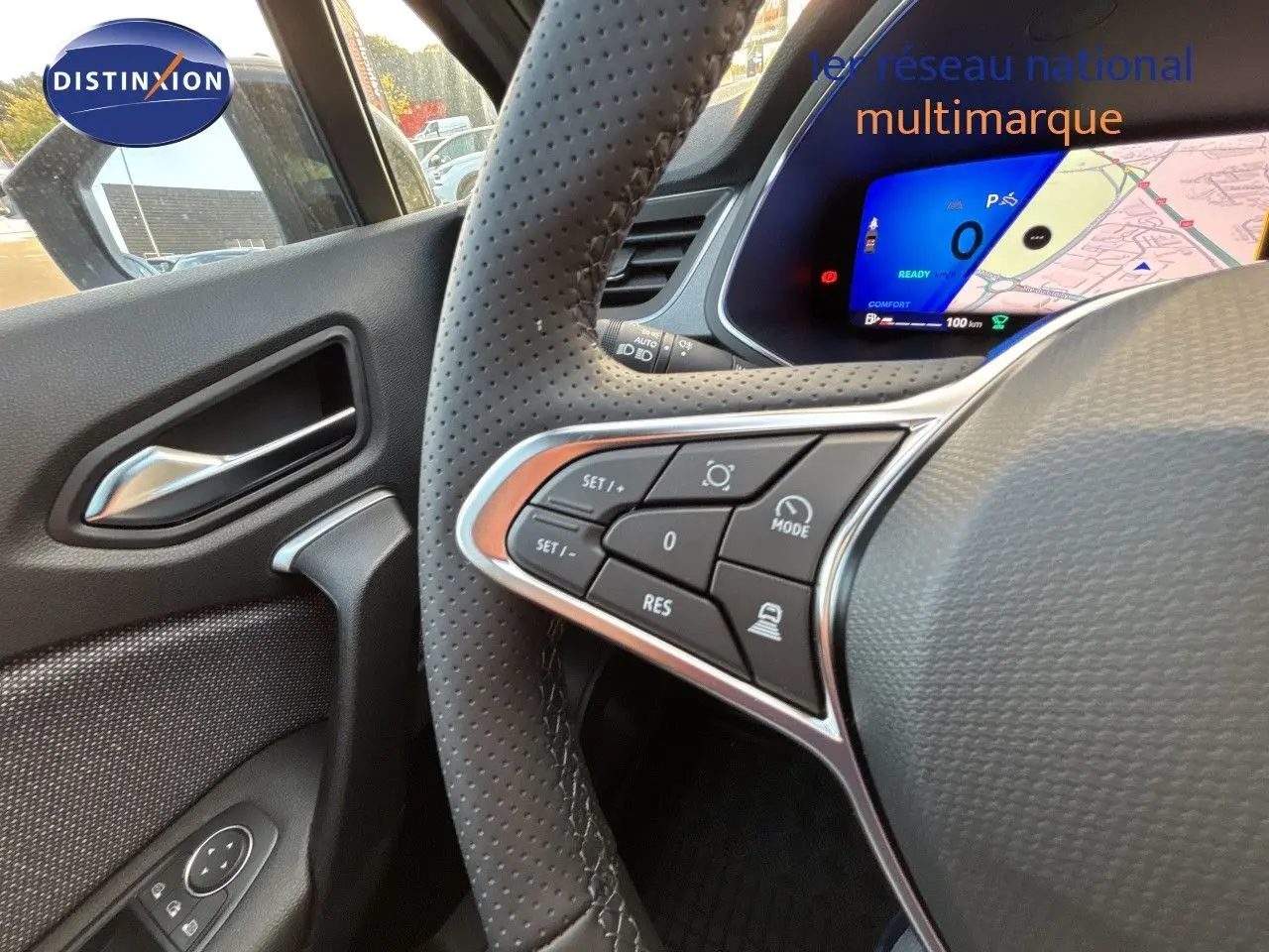 Vue intérieure côté gauche du volant perforé d'une Renault Symbioz gris cassiopée, avec commandes au volant et tableau de bord digital.