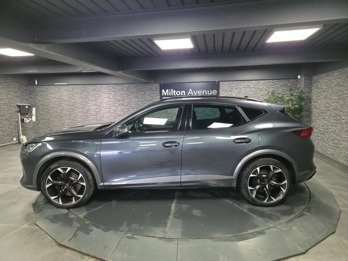 Vue de profil côté gauche du CUPRA Formentor gris, soulignant ses jantes alliage noires et détails de carrosserie sportifs.