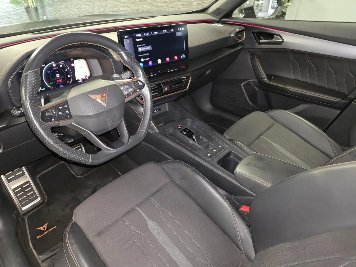 Vue intérieure côté conducteur du Cupra Formentor 2024, tableau de bord noir avec surpiqûres cuivre et écran tactile central.