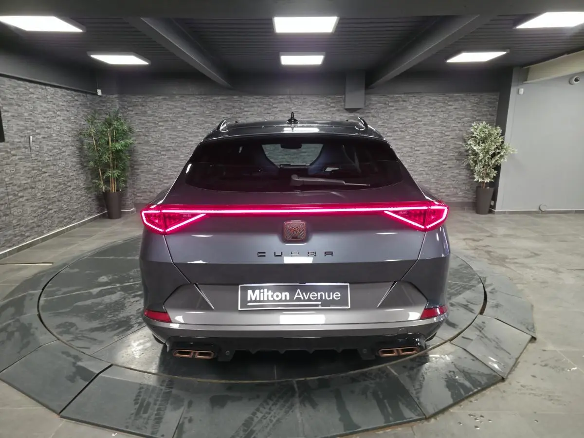 Vue arrière d'un CUPRA Formentor gris 2024 avec bandeau lumineux LED et double sortie d'échappement Copper stylisée.