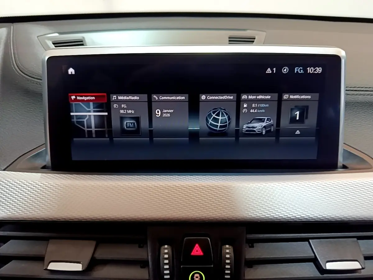 Écran tactile central 8,8 pouces du BMW X1 blanc, affichant navigation et informations du véhicule.