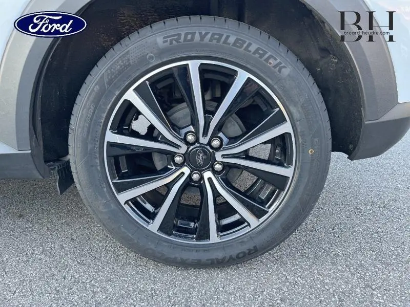 Gros plan sur la jante alu noire et argentée du côté avant droit du Ford Puma blanc 2022.